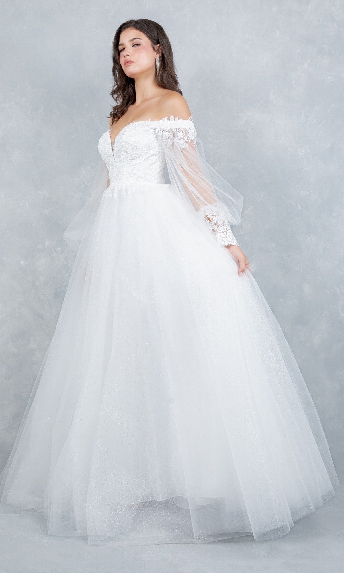 A woman wearing the Cinderella Couture 4233 long formal dress in off white, featuring an off-the-shoulder design with an embroidered bodice and sheer lace sleeves, stands against a light gray textured background.